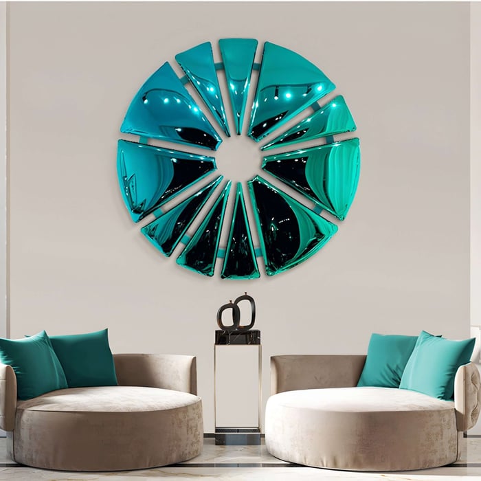 Two beige circular chairs with teal pillows sit in front of a large Giant Sculptures Halo Teal Segment Circle 3D Metal Wall Art.
