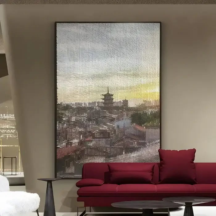 A contemporary interior with a large framed impressionistic cityscape artwork, featuring soft brushstrokes and warm hues above a deep red sofa.