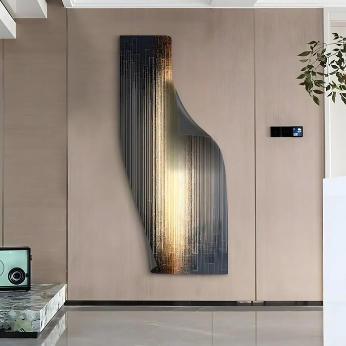 A striking, vertically oriented wall sculpture with cascading golden and black linear elements, set against a curved metallic surface in a modern space.