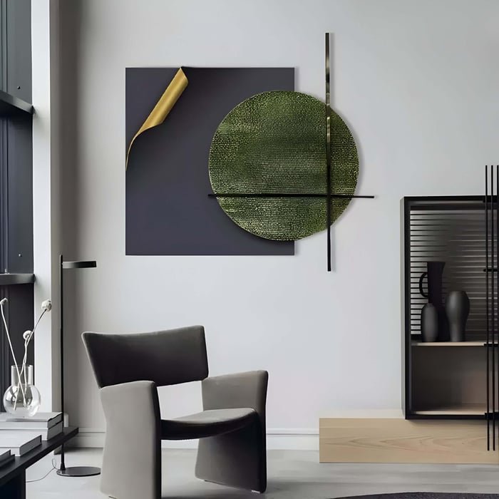 Abstract Geometric Art in Green and Gold – A striking contemporary metal wall sculpture featuring a dark panel with a partially peeled golden corner, intersected by a large textured green circle and sleek metal lines. Installed in a modern, monochromatic living space.