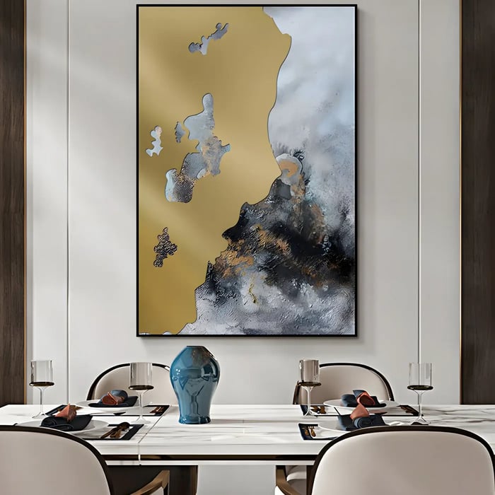 Gold and black abstract painting in a luxury dining room – A modern dining area with a tall framed artwork featuring gold and black textures on a neutral-toned wall.