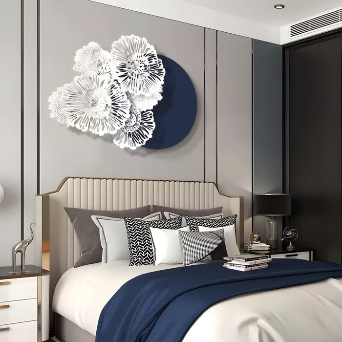  Floral white wall sculpture layered over a dark blue circle above a navy-accented bedroom headboard.