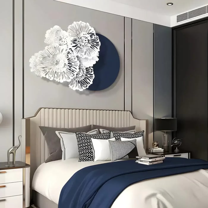 A refined bedroom with a three-dimensional white floral wall installation against a navy backdrop, harmonizing with the sophisticated neutral and navy-toned bedding.