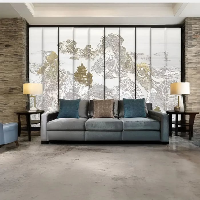 A luxurious living space with a panoramic multi-panel artwork depicting a traditional Asian-inspired mountain landscape behind a plush grey sofa.
