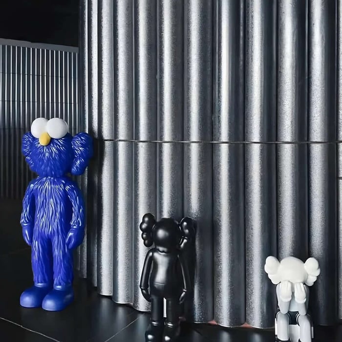 Trio of Iconify furry sculptures in blue, black and white standing against tall metal wall panels in a contemporary space.