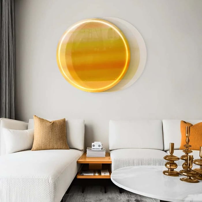 Round yellow gradient wall art glowing above a white sectional sofa with mustard cushions in a modern living room.