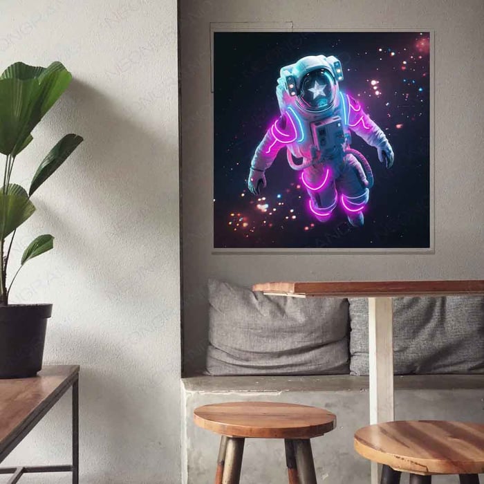 Neon-style artwork of an astronaut floating in space, glowing with pink and blue lights, hanging on the wall of a cosy café-style seating area.