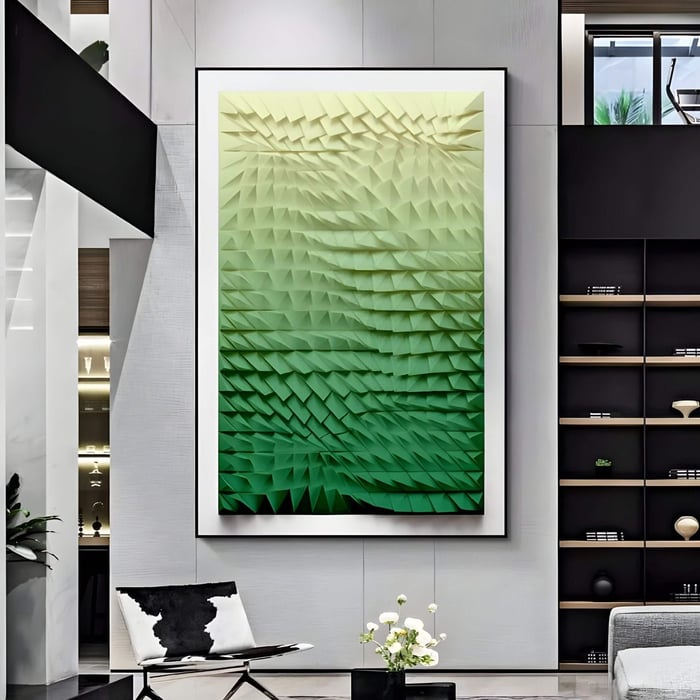 A modern living room features a striking Elorium Green Gradient Hand-Painted Wood Relief 3D Wall Art by Giant Sculptures, boasting a textured triangular pattern. The minimalist decor includes a black-and-white chair, small table, and shelves with books and decor items for an elegant touch.