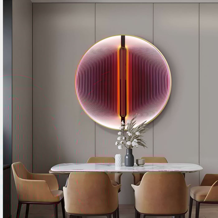 Vibrant circular wall sculpture with neon-like red and orange lines above a marble dining table.