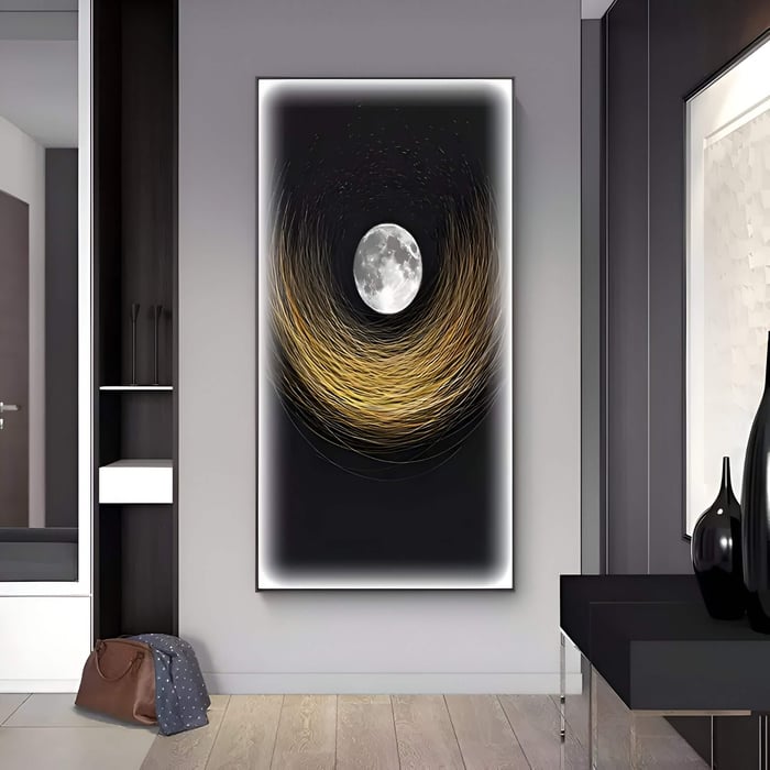 A sleek entryway showcases a dramatic vertical canvas art piece featuring a glowing full moon surrounded by swirling golden strokes against a deep black background, creating a luminous, celestial focal point.