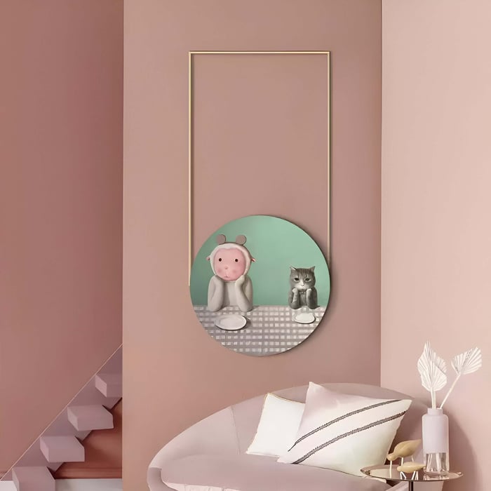Playful Hanging Circular Artwork – A round artwork featuring a soft character and cat, framed within a gold structure in a pink-toned room.