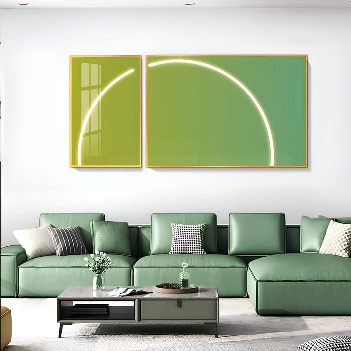 Two-panel green gradient artworks with glowing white arc lighting hang above a green sectional sofa, casting a futuristic glow in a bright modern lounge.