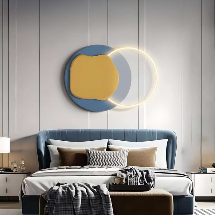 Circular wall art with intersecting yellow and blue shapes and glowing LED ring above a blue bed.