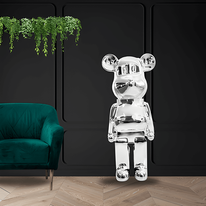 a chrome giant bear sculpture against a matt black living room wall with plants and a green velvet chair