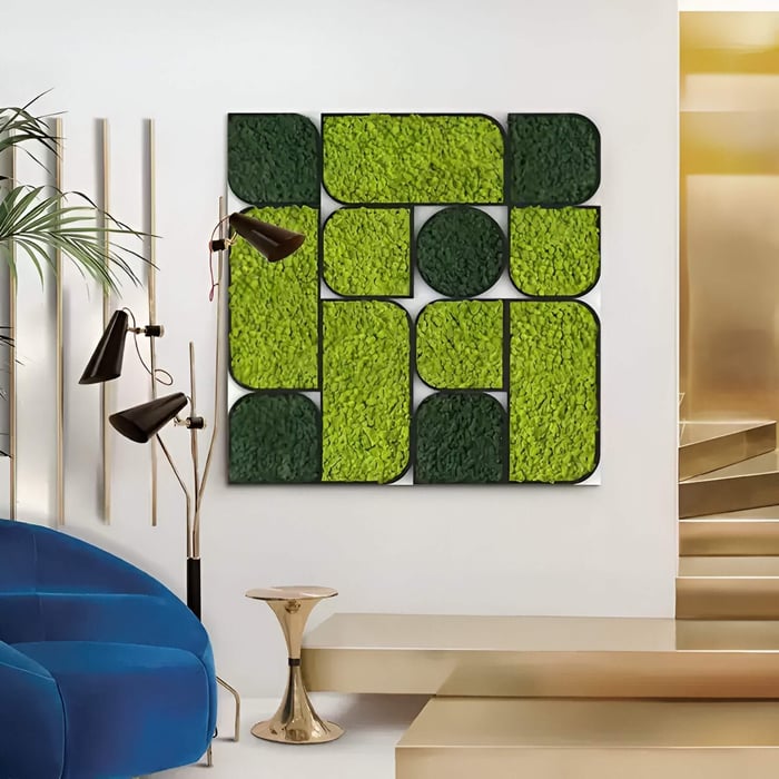 A contemporary living room featuring Verdura Square Green Moss Mosaic 3D Wall Art, a geometric wall installation made of vibrant green preserved moss panels in varying shades, adding a natural texture contrast against modern gold accents and a blue velvet chair.