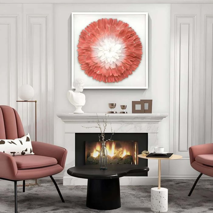Large framed coral-and-white flower-like feather artwork above a fireplace in a stylish lounge with blush chairs.
