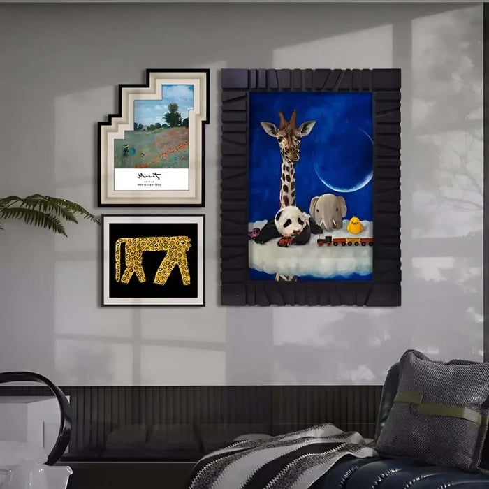 Modern lounge wall displaying two small framed prints beside a large blue painting of animals art on a cloud giraffe, panda, elephant, and chick set against a moonlit sky.