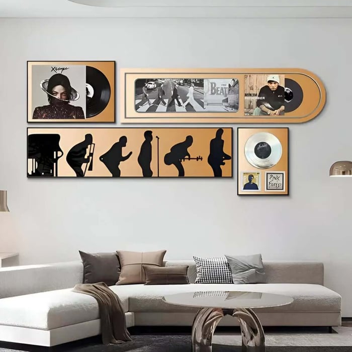 Music-themed wall art set with vinyl records and band imagery arranged above a modern sofa.