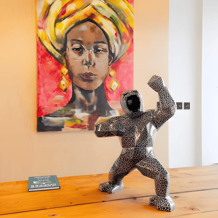 a black and white gorilla sculpture in front of a painting