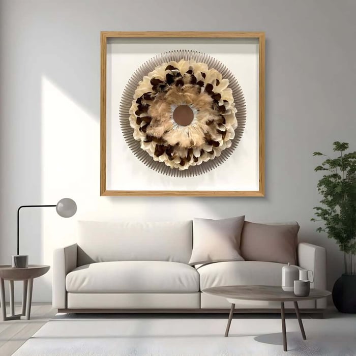 Large framed circular feather-style wall sculpture above a white sofa in a minimalist room.