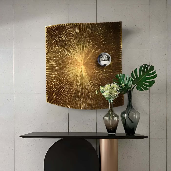 Golden metal 3D art with a radiant sunburst design and a polished metallic sphere, complemented by decorative vases on a modern console table.