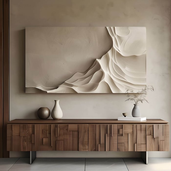 Contemporary wooden sideboard with geometric paneling beneath a beige abstract 3D wall art in a minimalist living space.