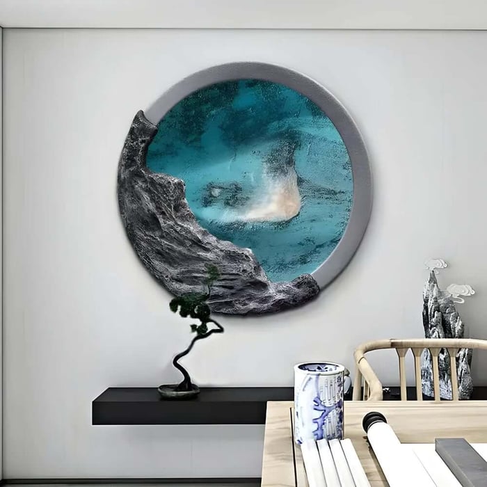 Round wall art with teal centre and rock-textured edge above a desk with decor, creating a modern office feel.