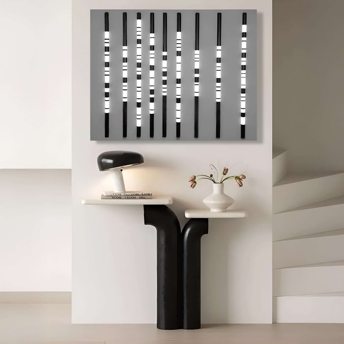 Black and white striped light installation above minimalist black-and-white console table.