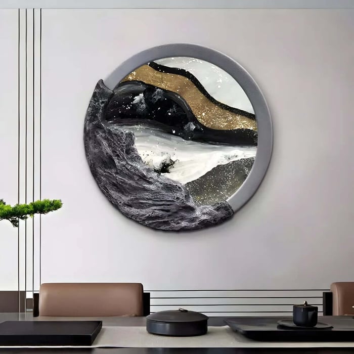 Circular wall sculpture with textured stone-like details and gold accents mounted above a modern meeting table.