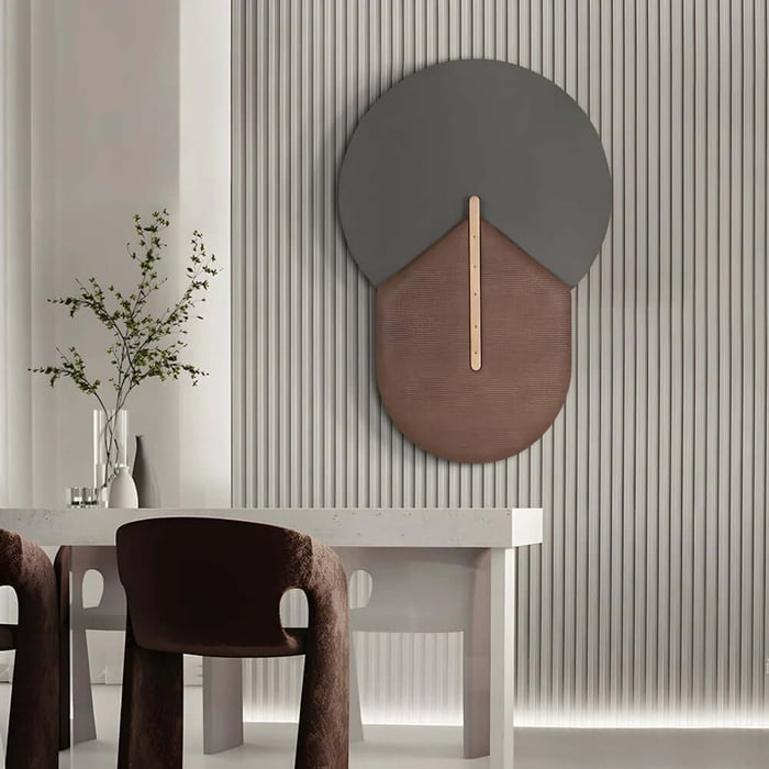 Minimalist dining or office space with a sculptural wall art piece in grey and brown on a ribbed feature wall.