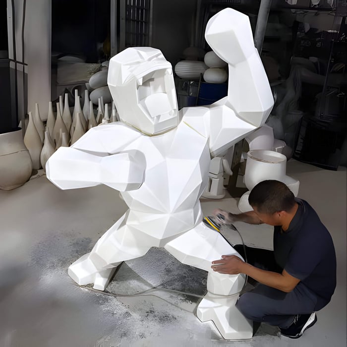 A luxury, giant white gorilla sculpture being completed by an artist