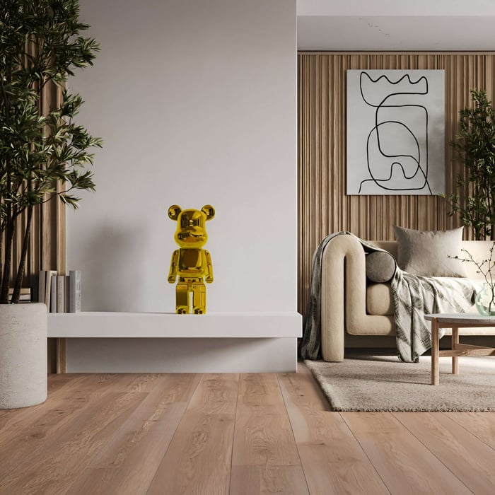 Stylish interior featuring a gold bear sculpture on a white console table, complemented by modern decor elements, a neutral-toned armchair, and wooden accent walls with greenery.