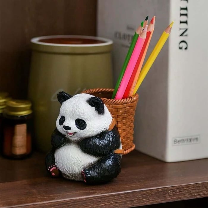 Cute resin panda pencil holder with woven basket design, holding colourful pencils on an office desk shelf.