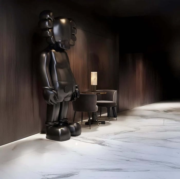 A tall matte black designer figure standing against a dark wooden wall in a modern hallway with marble flooring and minimal furniture.