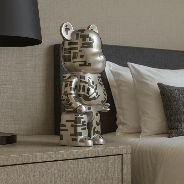 Silver bear-shaped sculpture with geometric patterns displayed on a bedside table next to a modern bed.