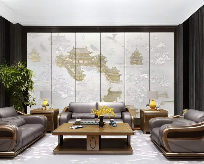 Elegant living room featuring modern brown leather sofas and a wooden coffee table. Decorative paneling with Silvienne Timeless Silk Wall Art from Giant Sculptures, adorned with 3D gold foil highlights, elevates the space. A leafy plant and tabletop ornaments add warmth and style.