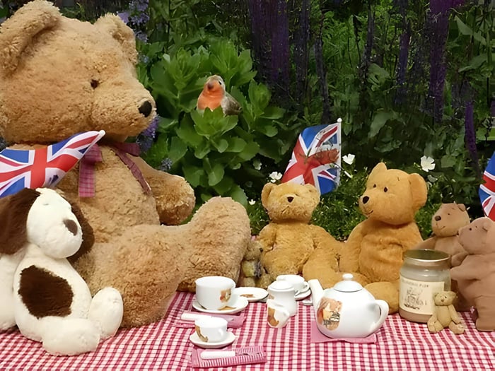 group of teddies having a picnic on a red and white blanket