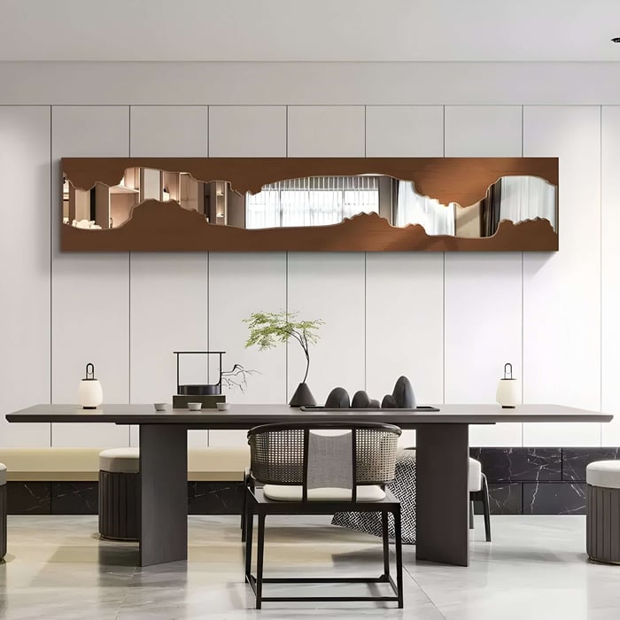 Abstract Mirror Wall Art with Organic Cutout Design – A contemporary mirrored wall sculpture with an irregular, organic cutout pattern framed in warm-toned wood, mounted above a sleek dining table in a modern space.