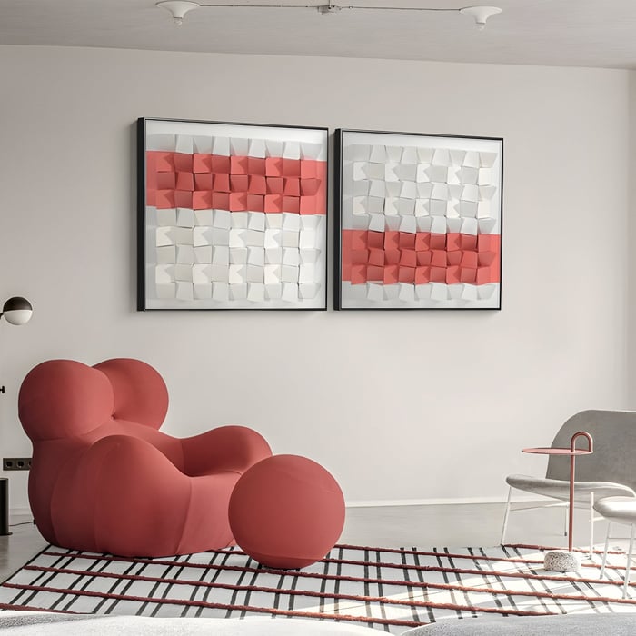 Red & White Grid Panel Wall Art – Dual 3D square pattern panels in soft red and white above a curved red lounge chair.