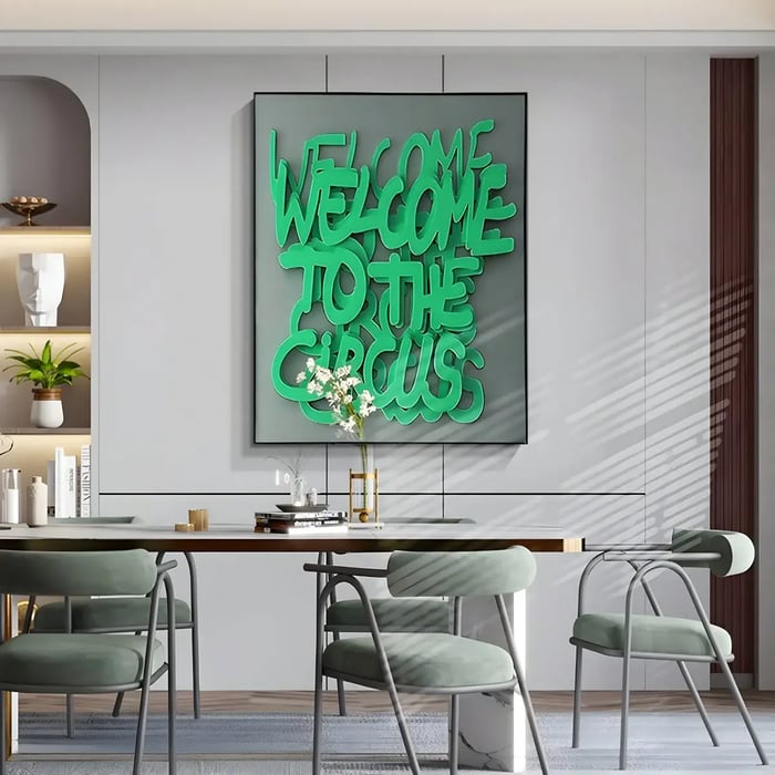 A dynamic, green-colored wall art featuring the text “Welcome to the Circus” in playful, curved letters, displayed in a contemporary dining room with minimalist seating and décor.