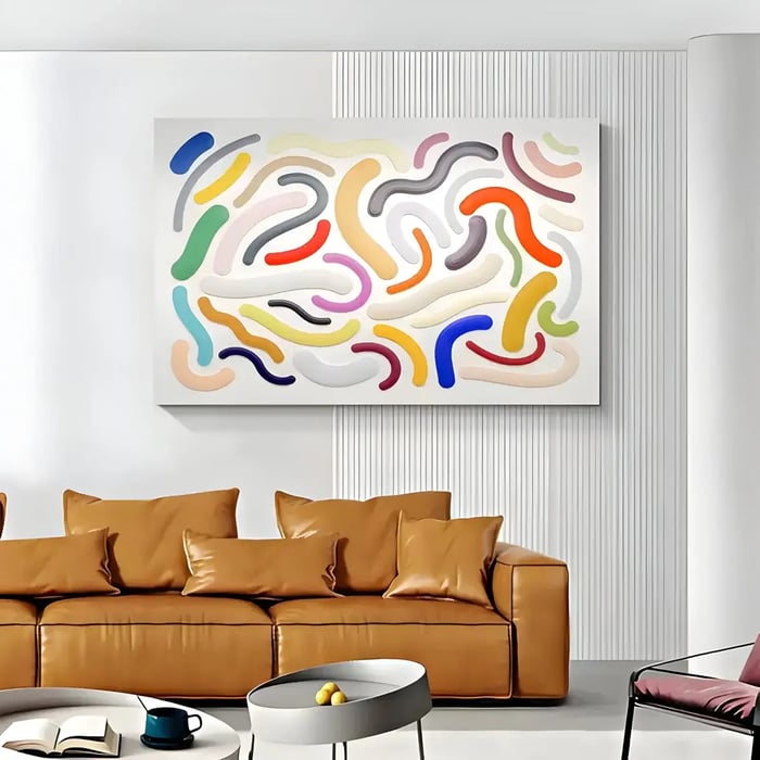 A modern living room with a large, colorful abstract wall art piece featuring curved, raised patterns in vibrant hues, complementing a tan leather sofa.