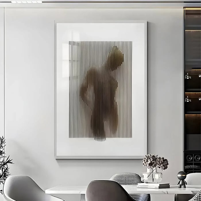 A modern and artistic wall art featuring vertical black lines that create a blurred silhouette of a human figure, set in a contemporary living room with minimalist design elements