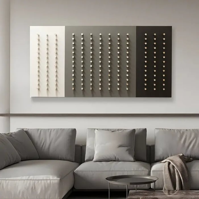 A modern triptych featuring a gradient of white, grey, and black panels adorned with evenly spaced 3D dots, complementing a neutral-toned living space.