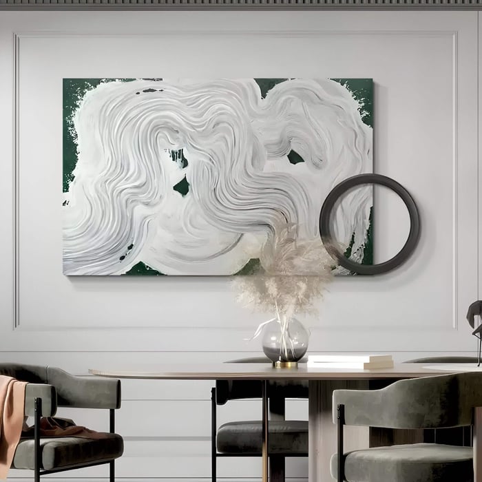 Large abstract art combining expressive white swirls with a solid dark circle, creating a fluid contrast above a dining table and pampas arrangement.