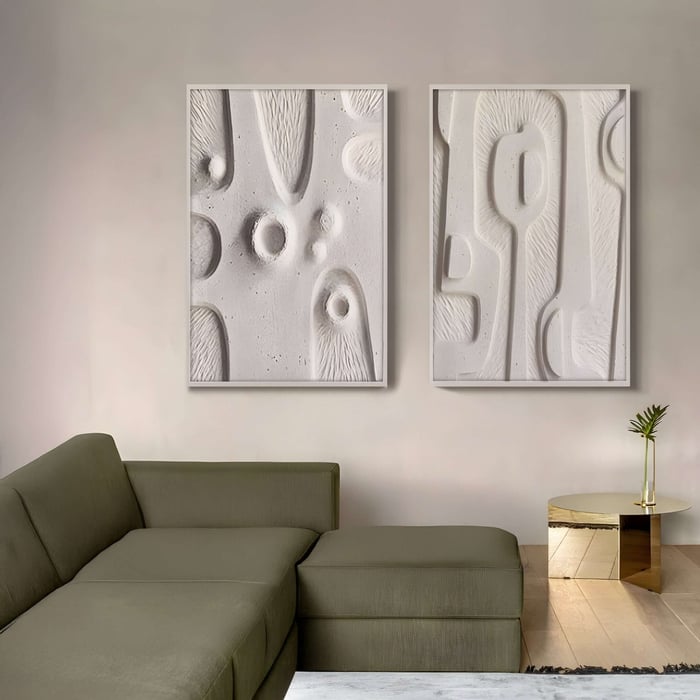 A modern living room showcases a green sectional sofa, a small gold side table with a plant, and Terravura Rectangular Soft White II 3D Wood Relief Wall Art by Giant Sculptures on a beige wall. Light wood flooring adds warmth, complemented by thoughtfully placed 3D wood accents.