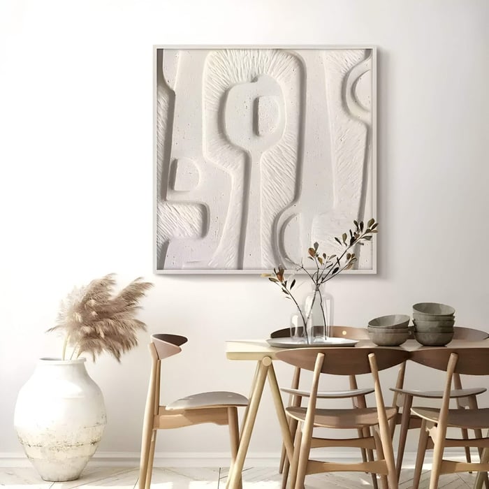 A modern dining space includes a wooden table, chairs, two glass vases with branches, and a floor vase with pampas grass. The serene ambiance is enhanced by Giant Sculptures Terravura Square Soft White I 3D Wood Relief Wall Art on the wall.