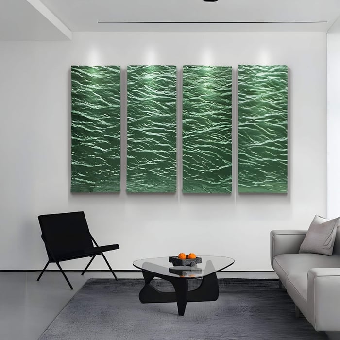 A modern living room features a white sofa, black chair, and glass coffee table with a small plant and books. The serene atmosphere is enhanced by Giant Sculptures Illume 4-Panel Green Hand-Painted Wood Relief 3D Wall Art depicting textured waves.