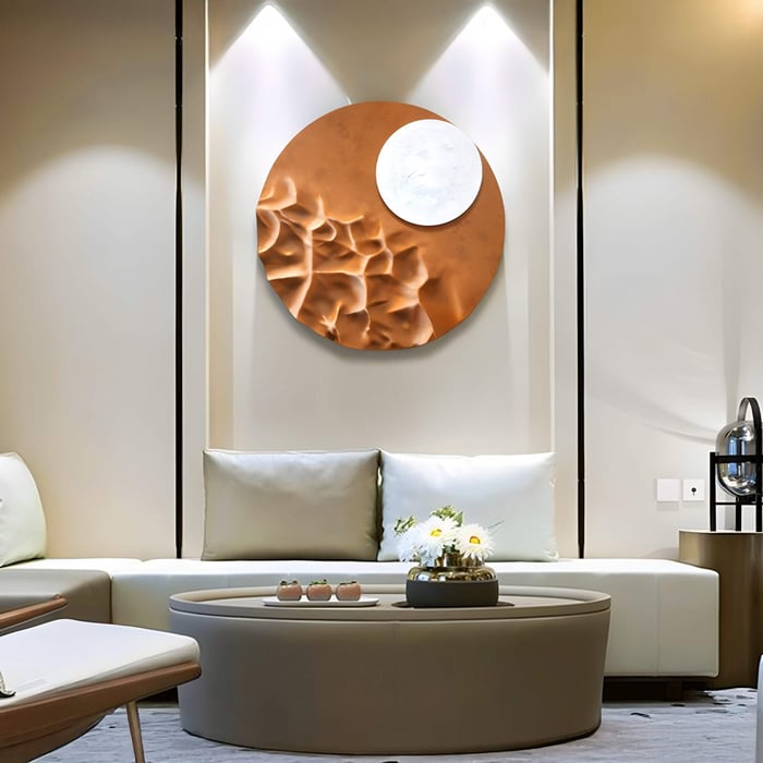 Round copper and white sculptural wall art illuminated by spotlights above a curved seating area with soft-toned furnishings.