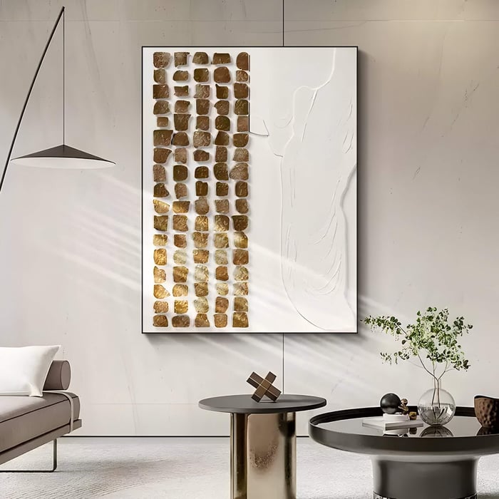  Elegant organic art with a grid of gold tiles and white embossed design in a neutral-toned contemporary space.