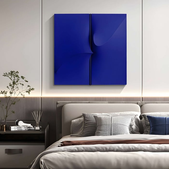 Deep blue abstract 3D canvas art above a neutral upholstered bed in a modern minimalist bedroom.
